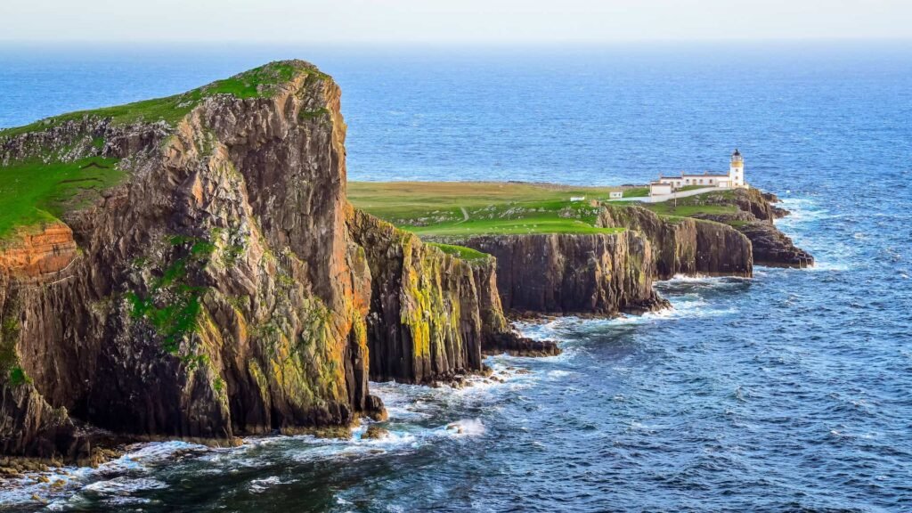 View of Neist Point lighthouse and rocky ocean coastline, highlands of Scotland.