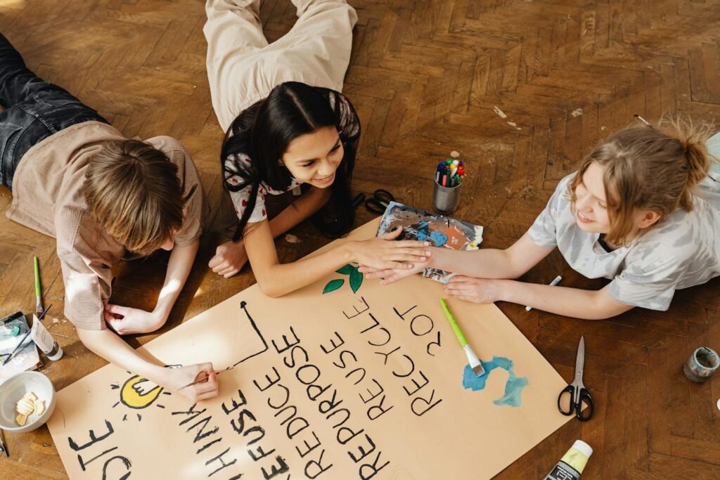 Kids creating a recycling poster together on the floor