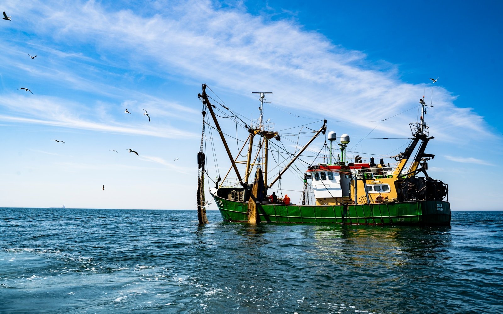 A fishing boat harvesting fish in the water.