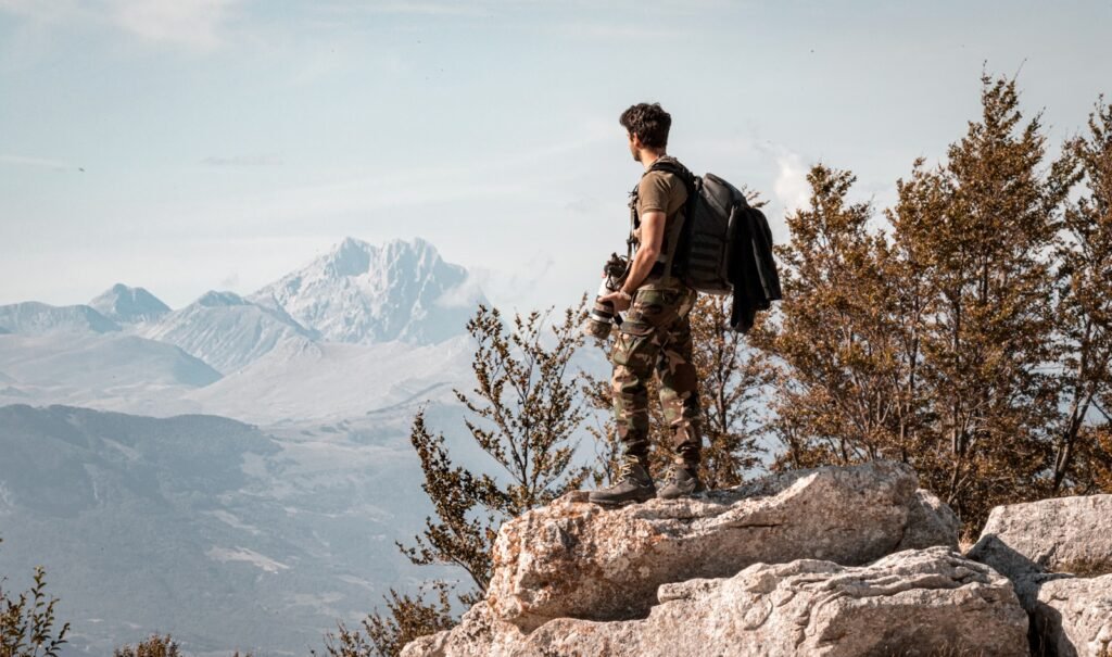 A wildlife photographer on a mountain ledge.