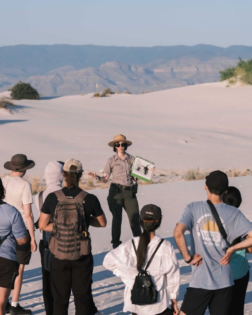 Group of tourists with a park ranger exploring White Sands National Park during daytime.