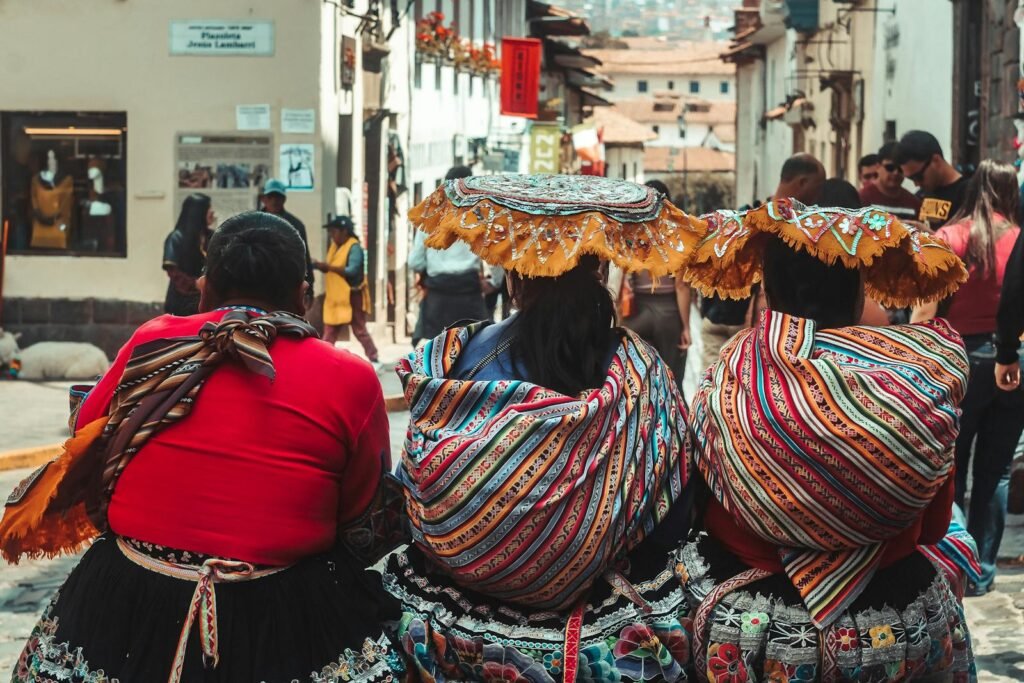 Women in vibrant traditional dresses in the streets of Cusco, Peru, showcasing cultural heritage.