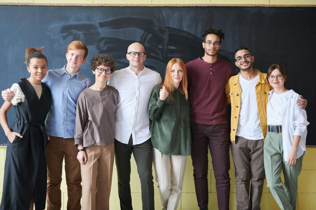 Group of eight people posing together in a classroom setting