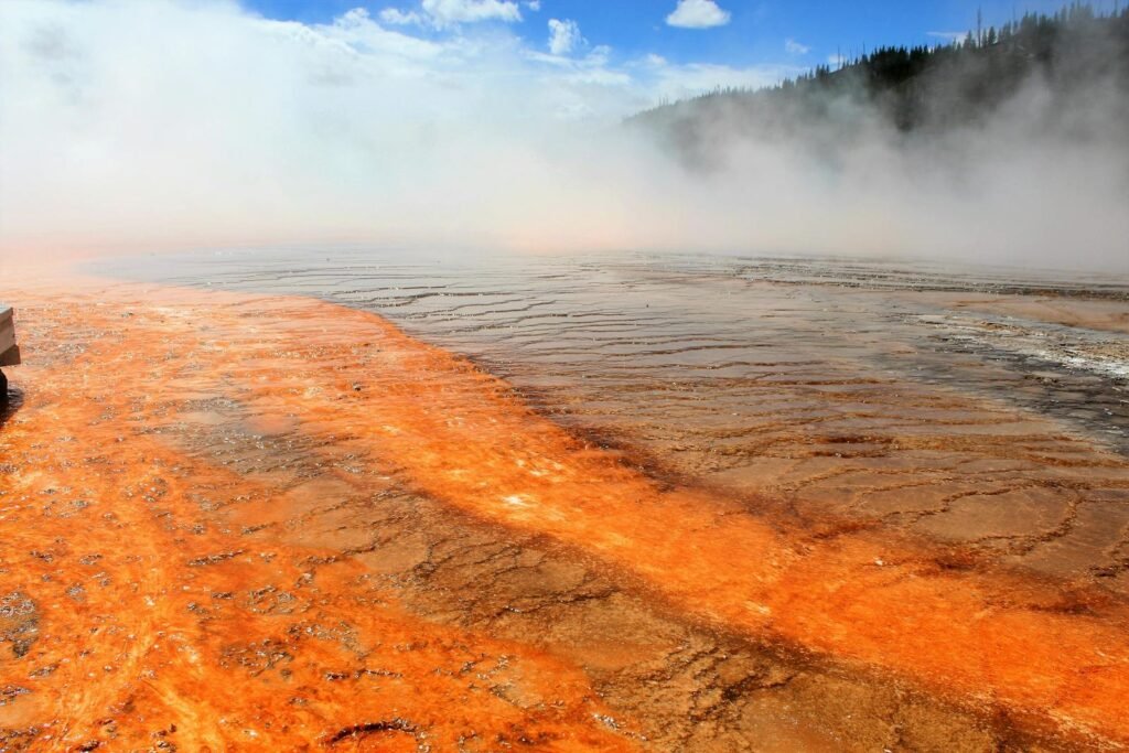 Colorful geothermal features and steam in Yellowstone National Park's dynamic landscape.
