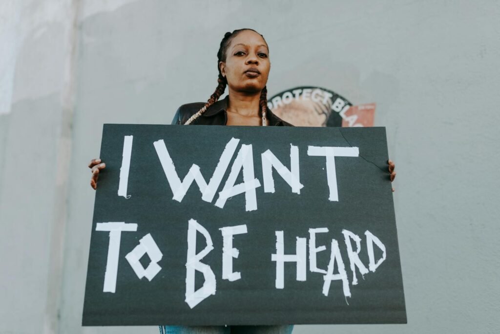 Young woman holds a protest sign outdoors, advocating for being heard.