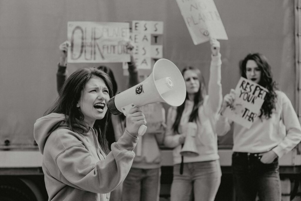 Group of young activists protesting with signs and a megaphone for environmental causes.