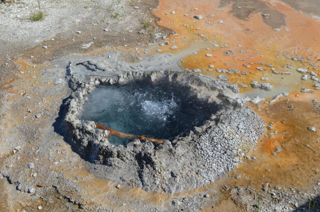 A bubbling geyser at Yellowstone National Park showcasing colorful geothermal features.