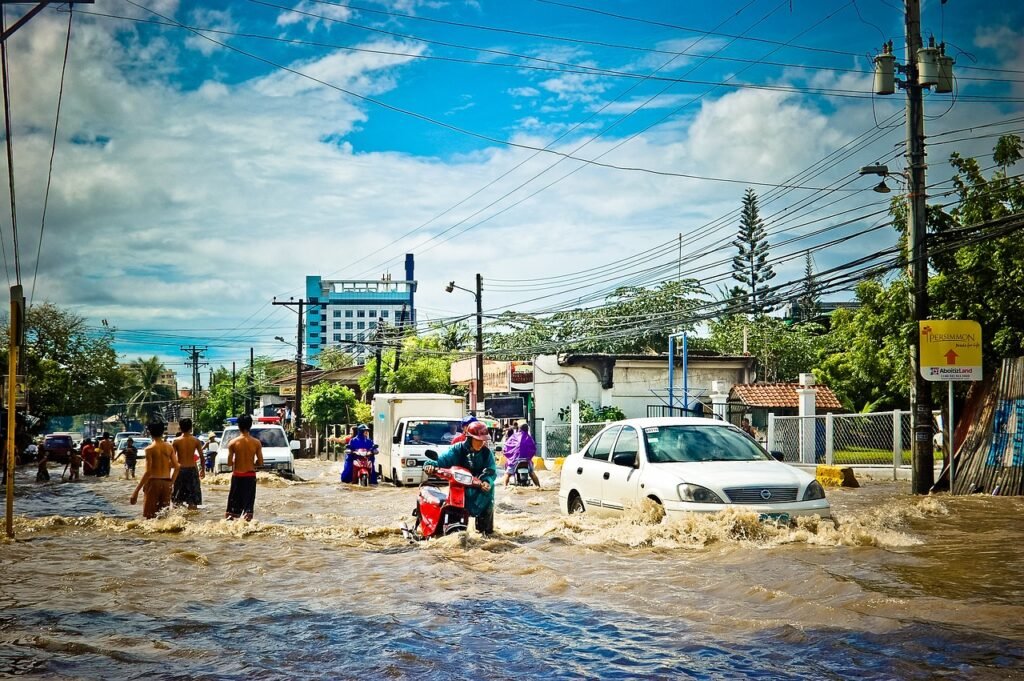 Flooded street with people and cars submerged in water