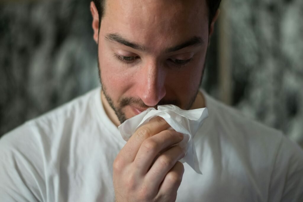 Person with allergies wiping their nose.