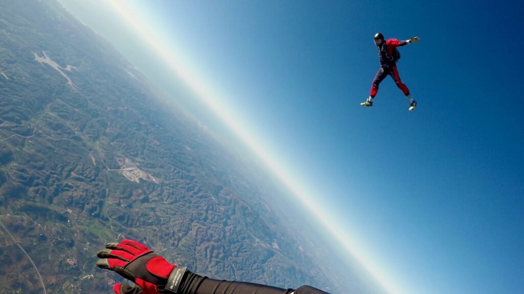 man in red and black outfit air diving.
