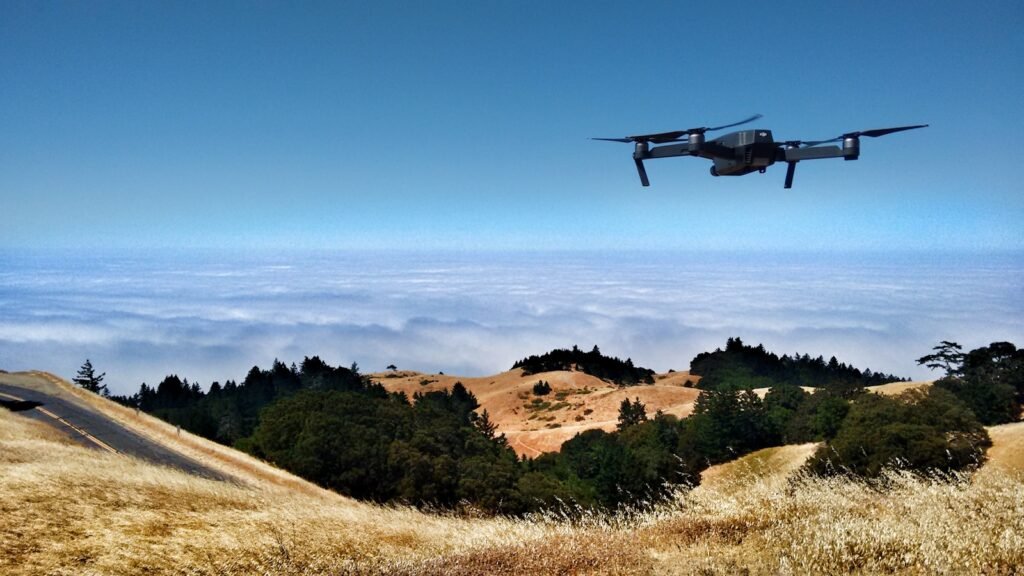 Black drone on air over cloudy sky at daytime.