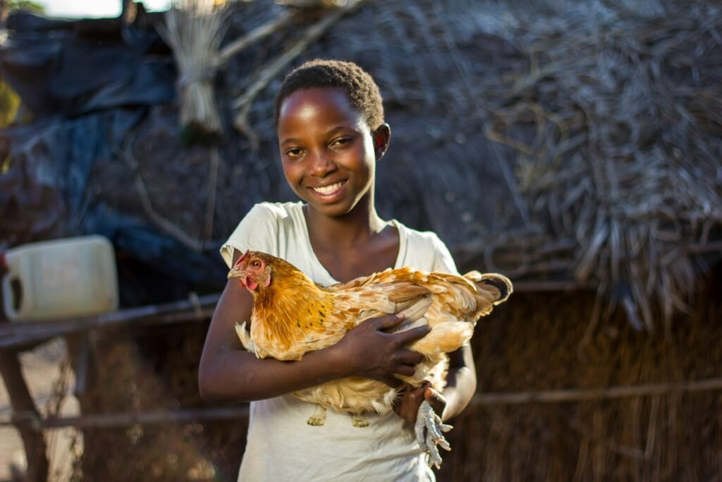 Girl holding a chicken in her hands.