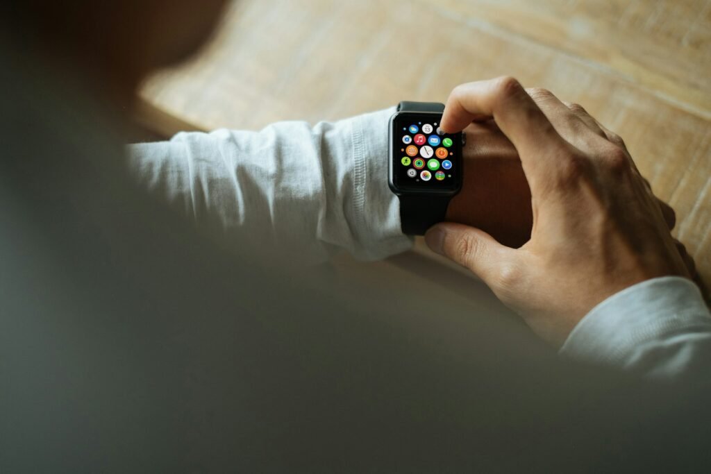 Person using a smartwatch with colorful app icons.