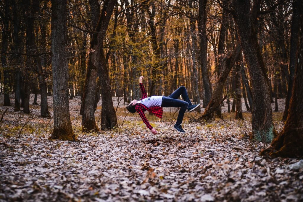 A woman is doing a handstand in the woods