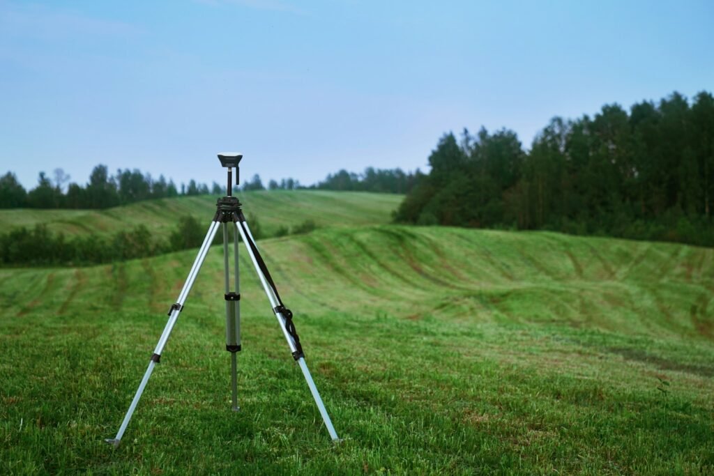 black and white tripod on green grass field during daytime.