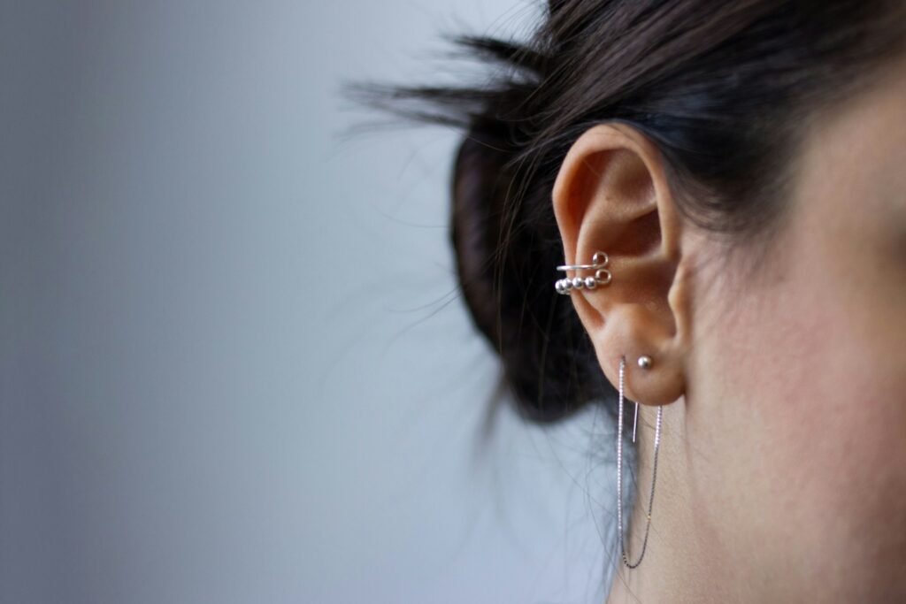 Silver colored earrings on her ears.