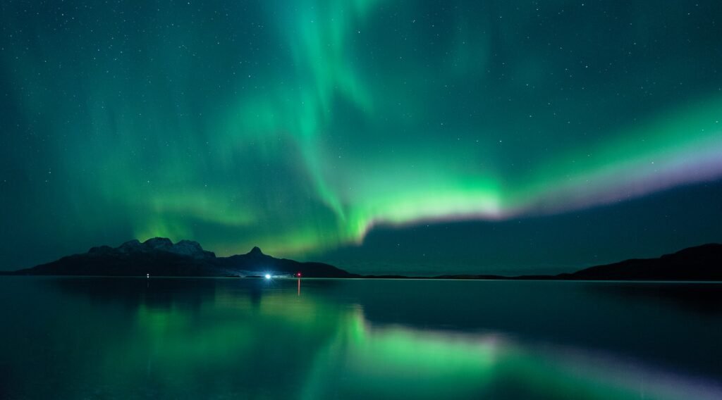 Green aurora lights over lake