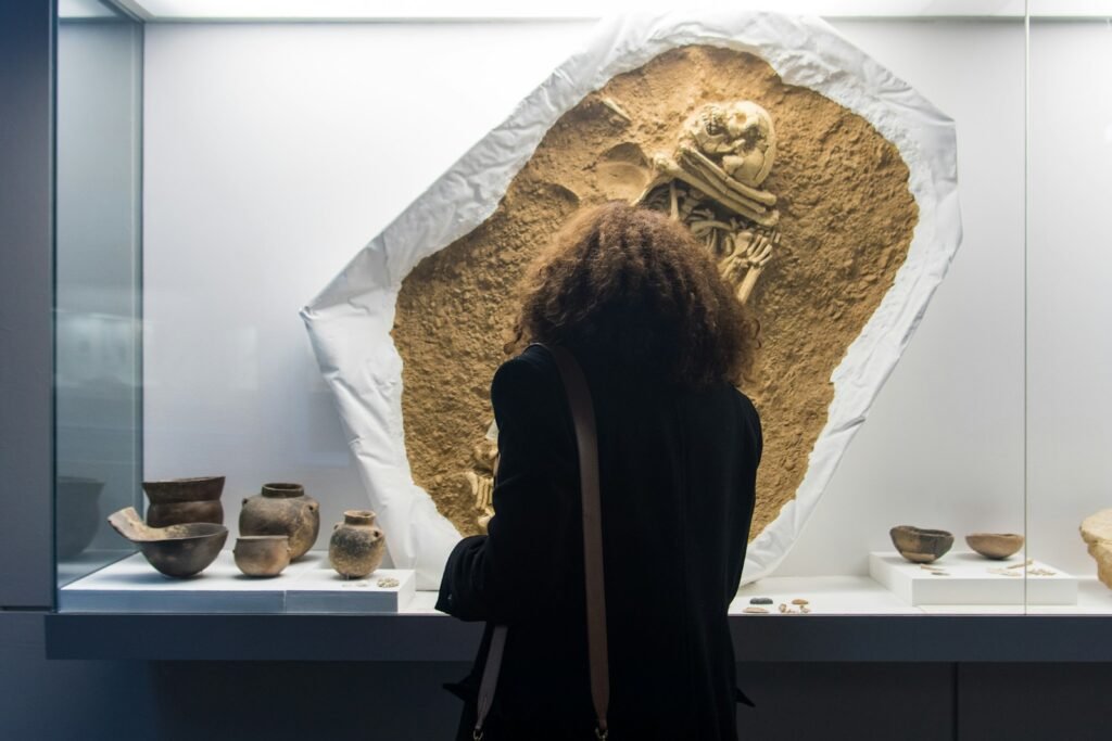 Woman standing in front of a display of neolithic burial.