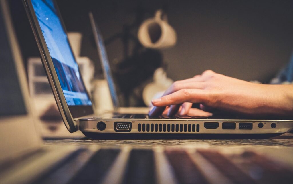 Person using silver laptop computer.
