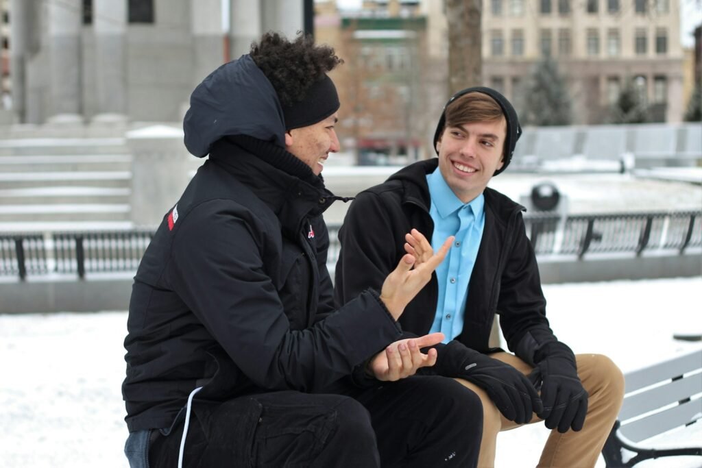 Men talking while sitting on a bench.
