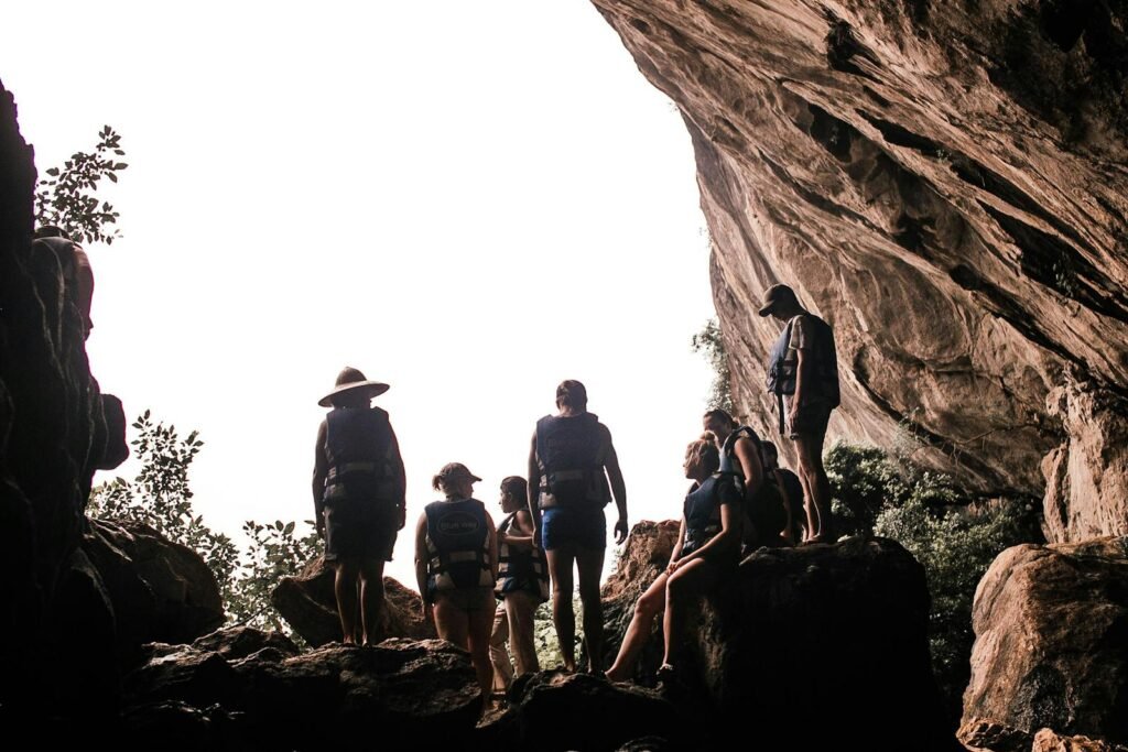 A diverse group standing inside a large natural cave, capturing the essence of adventure.