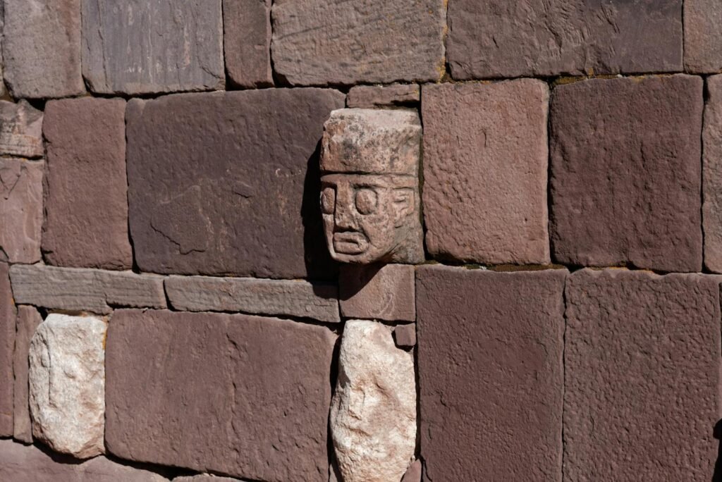 Close-up of carved stone an ancient wall in Tiwanaku, Bolivia, featuring intricate details.