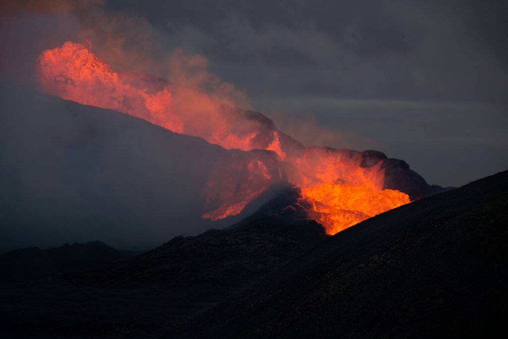 Dramatic scene of a volcanic eruption with glowing lava at twilight.
