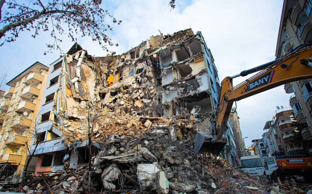 A partial demolition of a damaged building with heavy machinery in Malatya, Türkiye.