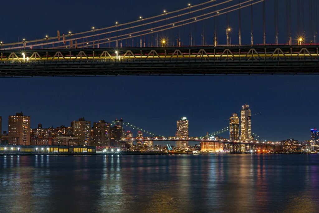 Stunning nighttime view of Manhattan skyline with Brooklyn Bridge, New York City.