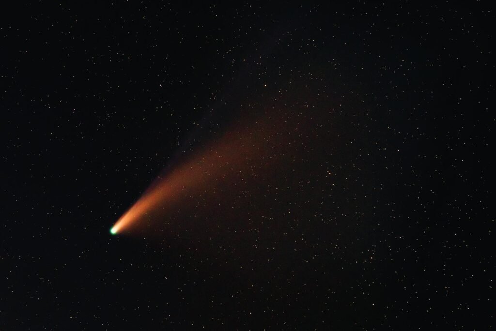 A vibrant comet with a glowing tail traversing the starry night sky, showcasing the wonders of the universe.