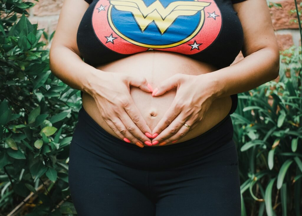 Woman with her hands around her navel.