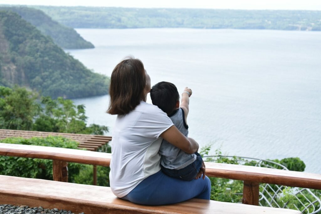 Two tourists sitting on a bench near Taal Volcano. 