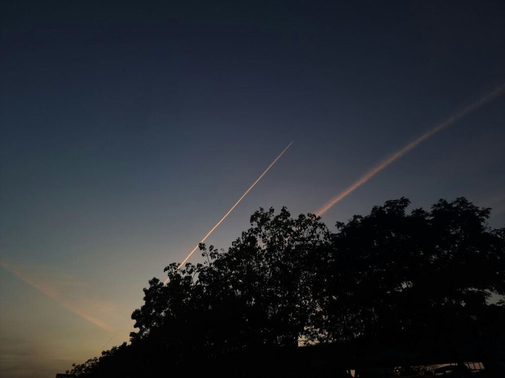 a plane is flying in the sky over a tree