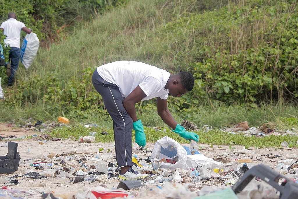 A man collecting plastic waste at the beach