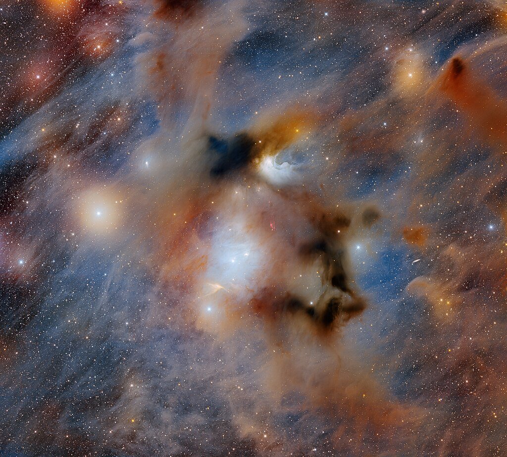 The ominous Chamaeleon I dark cloud, the nearest star-forming region to Earth, is captured in this image taken with the 570-megapixel Department of Energy-fabricated Dark Energy Camera mounted on the U.S. National Science Foundation Víctor M. Blanco 4-meter Telescope at Cerro Tololo Inter-American Observatory, a Program of NSF NOIRLab. Chamaeleon I is one portion of the larger Chamaeleon Complex and is home to three reflection nebulae that are brightly illuminated by nearby newly formed stars.