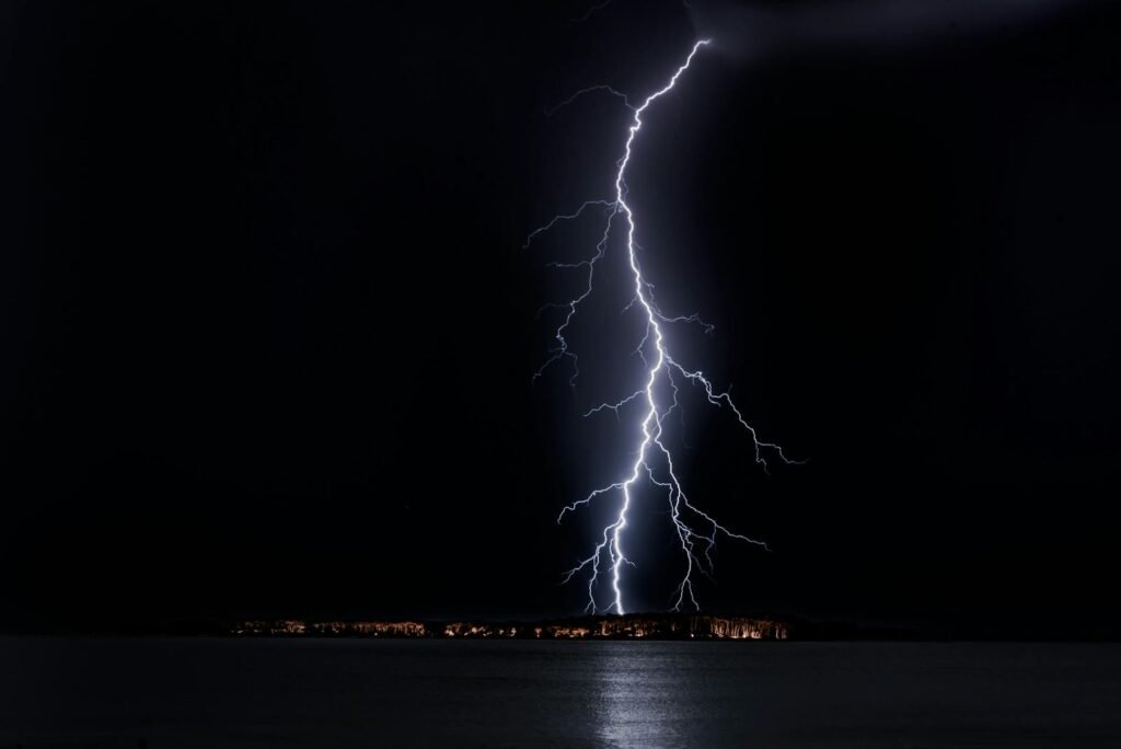 Stunning nighttime lightning bolt captured over ocean, casting eerie glow in Uruguay.