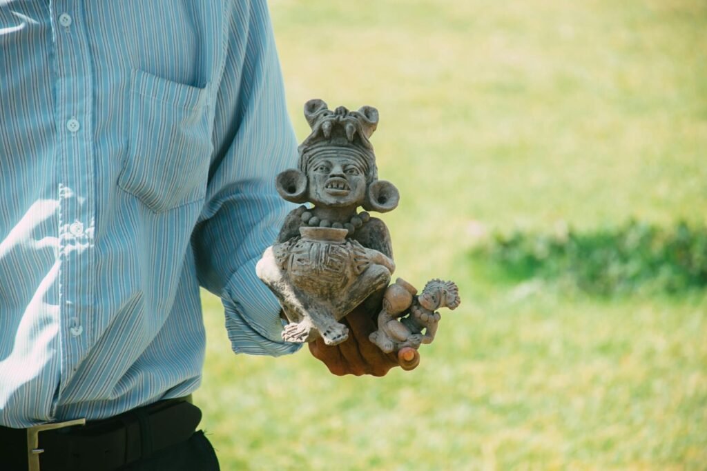 Close-up of a Zapotec figurine held outdoors, showcasing ancient Mexican art.