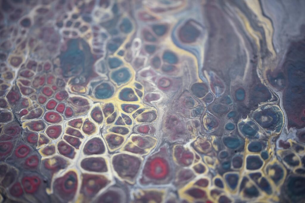 Close-up of colorful abstract fluid painting with red, blue, and yellow patterns.