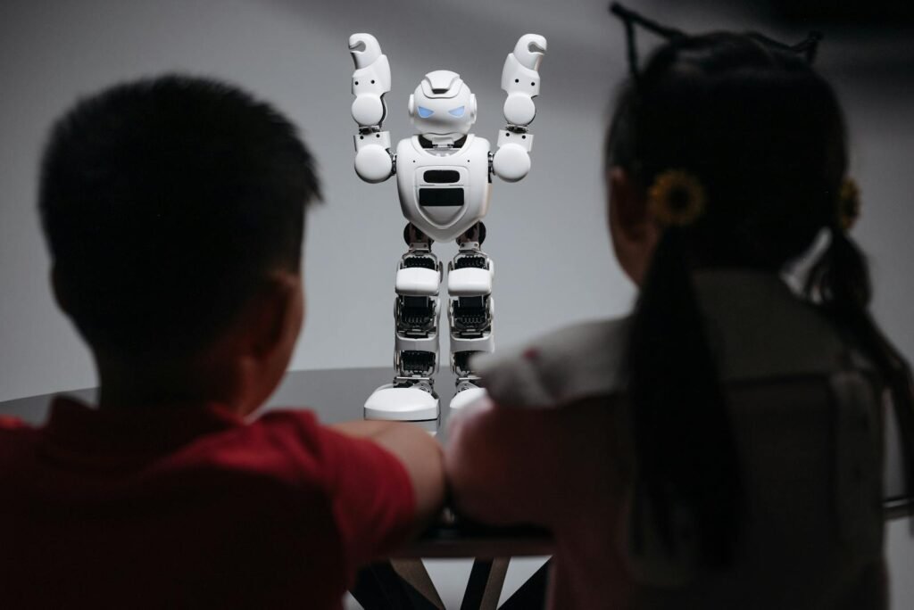 Two children observe a humanoid robot on a table, exploring technology and innovation.