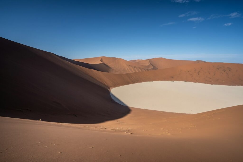 Dry lakebed in the desert under blue sky during daytime.