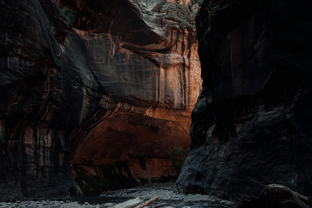 brown rocky mountain beside body of water during daytime