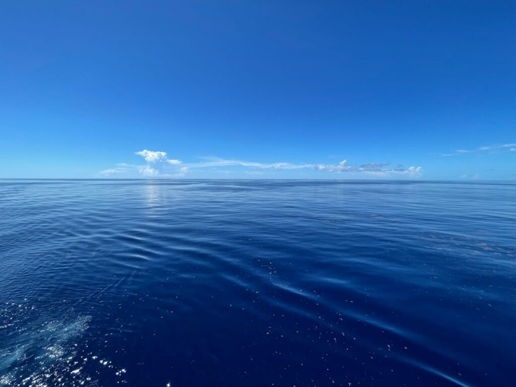 a body of water with a blue sky and clouds