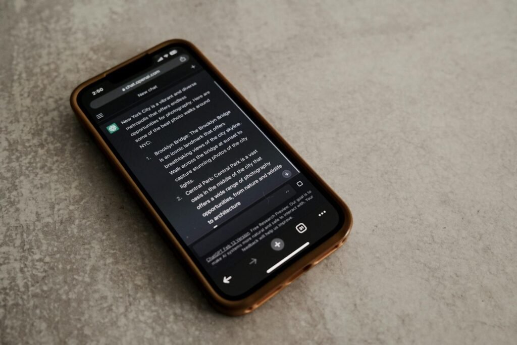 Close-up of smartphone with text about New York City tourist spots. Technology and communication theme.