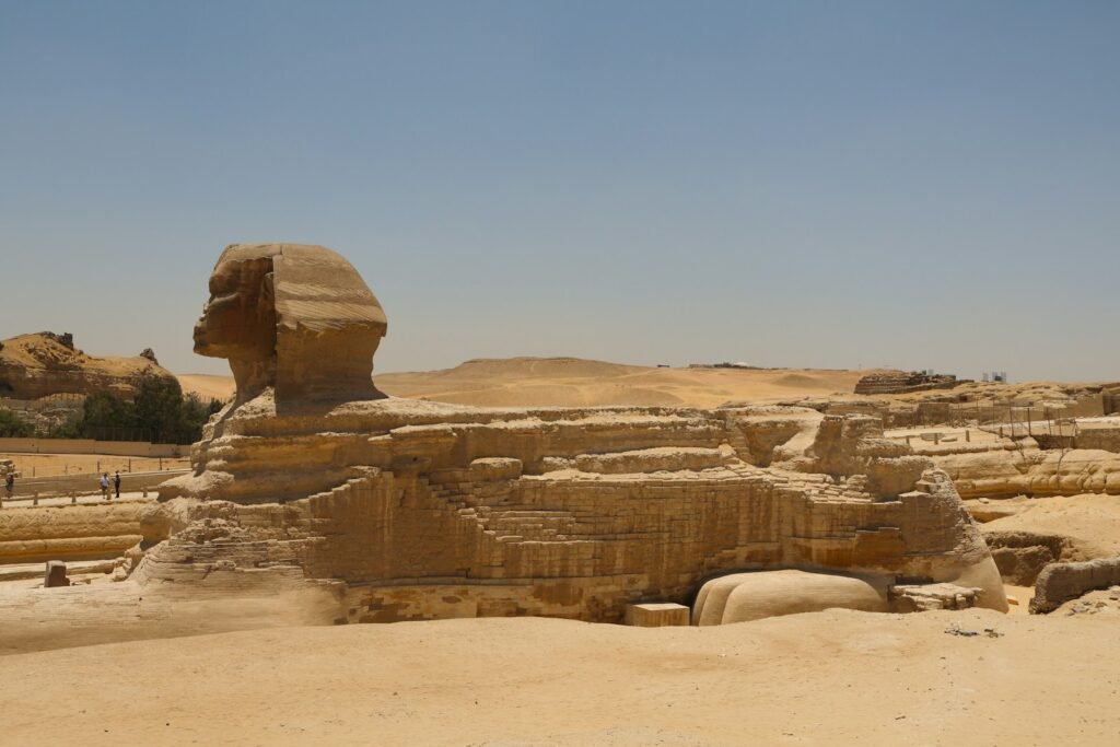 A large sphinx statue in the middle of a desert.