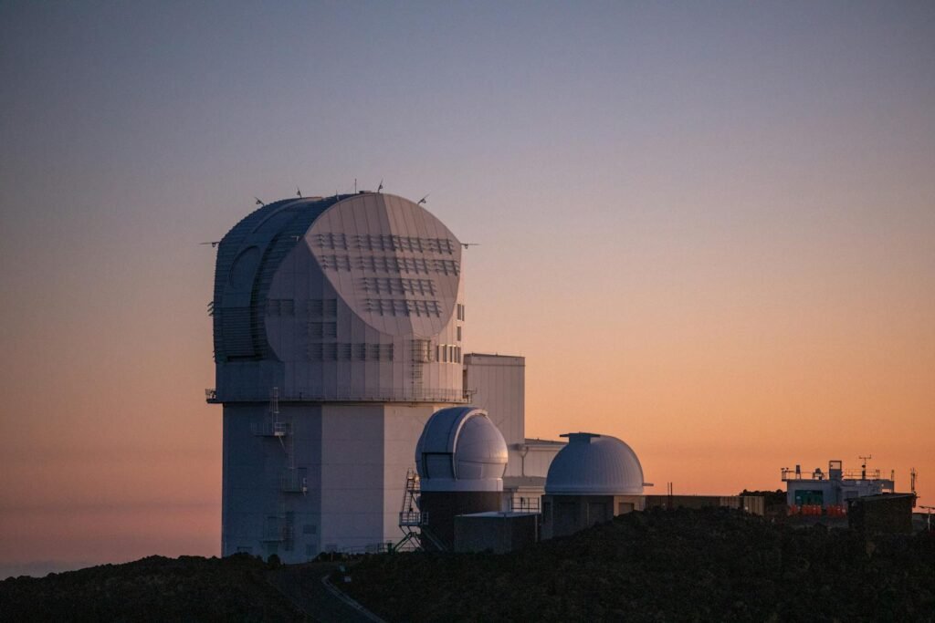 Modern solar observatory under a colorful sunset sky, showcasing architectural elegance against a serene backdrop.