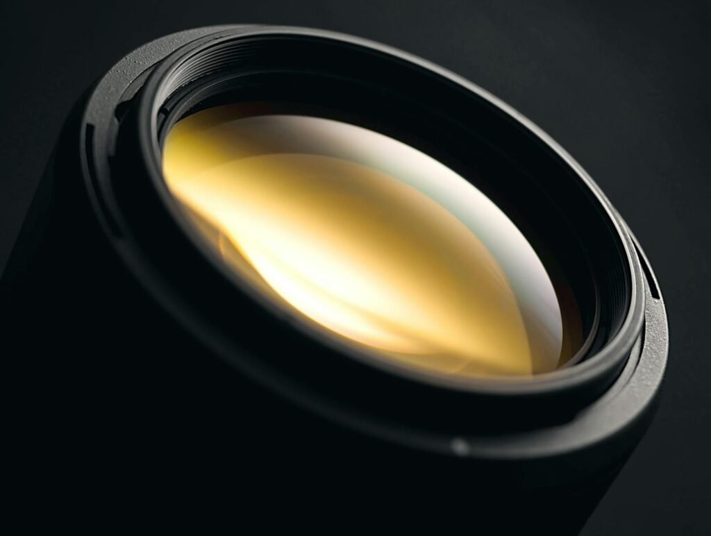 Detailed close-up of a camera lens showcasing reflective glass coating and sleek design.