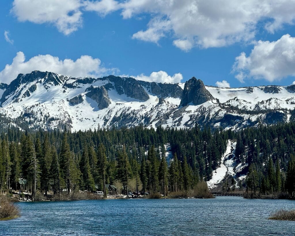A lake surrounded by snow covered mountains under a blue sky