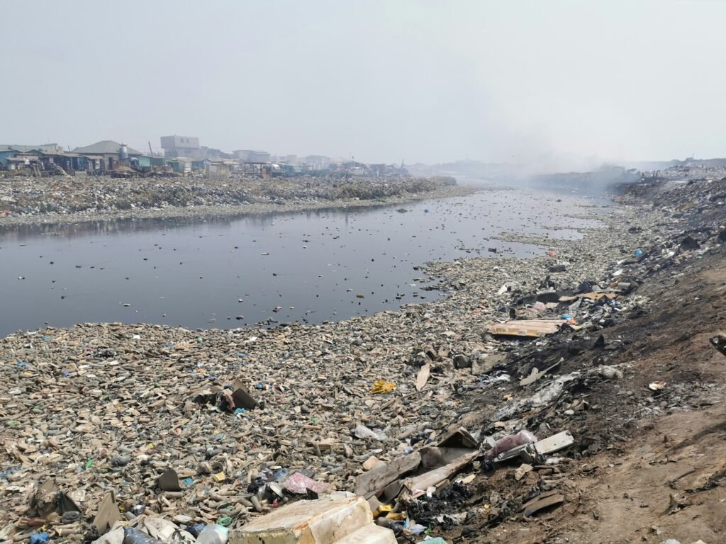 a large amount of trash is on the shore of a river