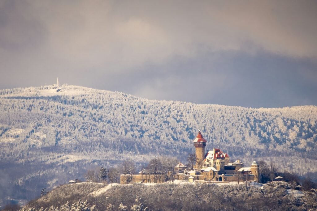 white and red concrete building on top of mountain during daytime