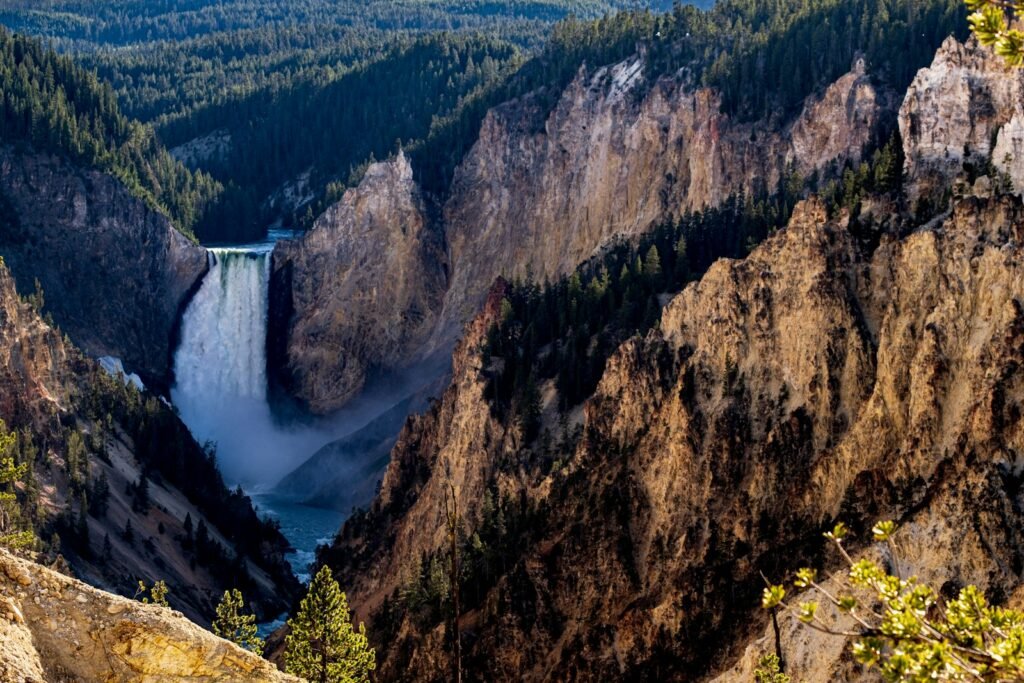 waterfalls in the middle of brown and green mountains